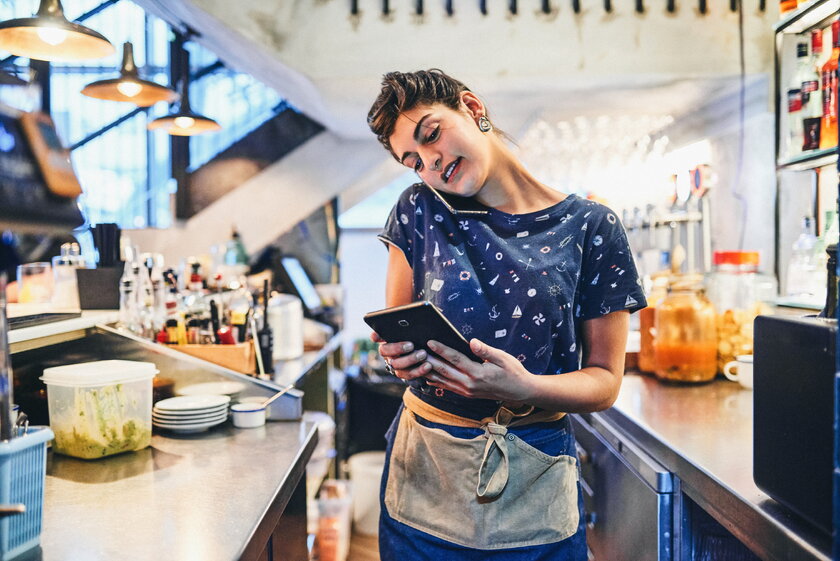 Bild Food Truck Managerin im Foodtruck telefoniert, um Bestellungen bei Lieferanten aufzugeben.