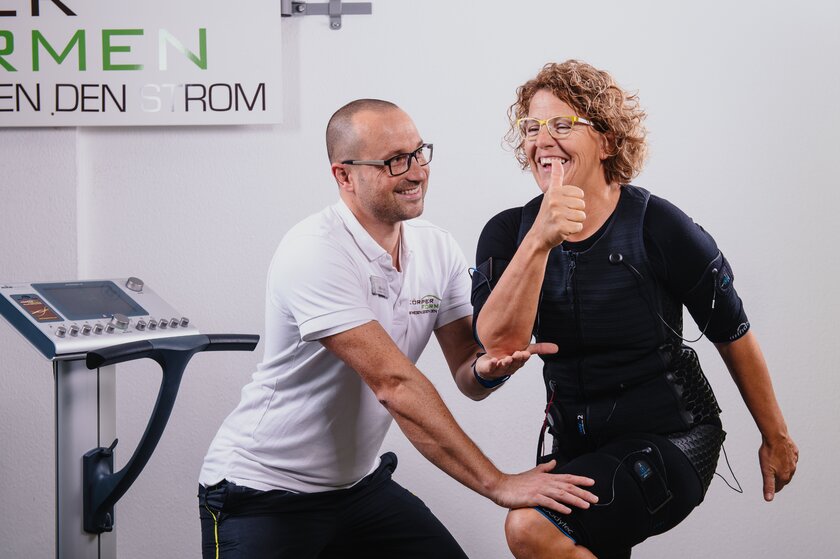 Bild Koerperformen Training Koerperformen Coach bietet gezieltes Muskeltraining an weiblicher Patientin.