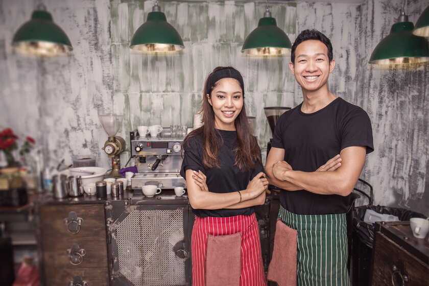 Aufnahme eines asiatischen Gruender-Duos, Mann und Frau in ihrem Café oder Restaurant.