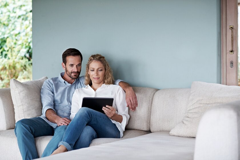 Bild Onlinesuche Aufnahme eines Paares Mann und Frau mit einem Tablet auf dem heimischen Sofa.