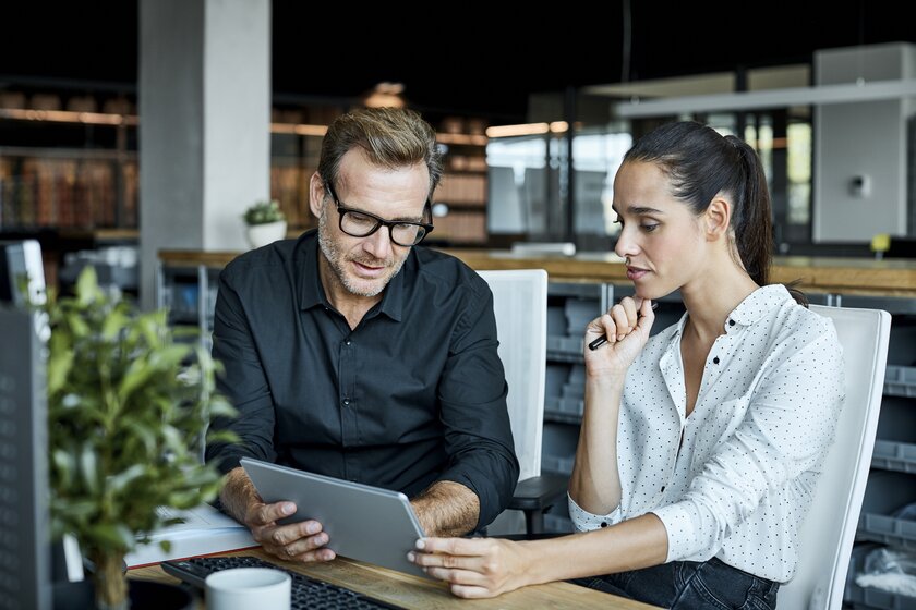 Berater und Unternehmerin geben Businessplan am Laptop den letzten Schliff.