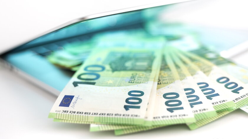 Bild 100-Euro-Laptop Mehrere 100-Euro-Noten liegen auf einer Laptop-Tastatur.