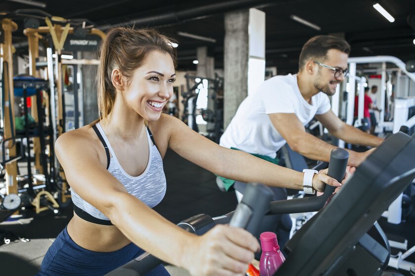 Bild Fitnessstudio Mann und Frau beim Fahrradfahren im Gym.