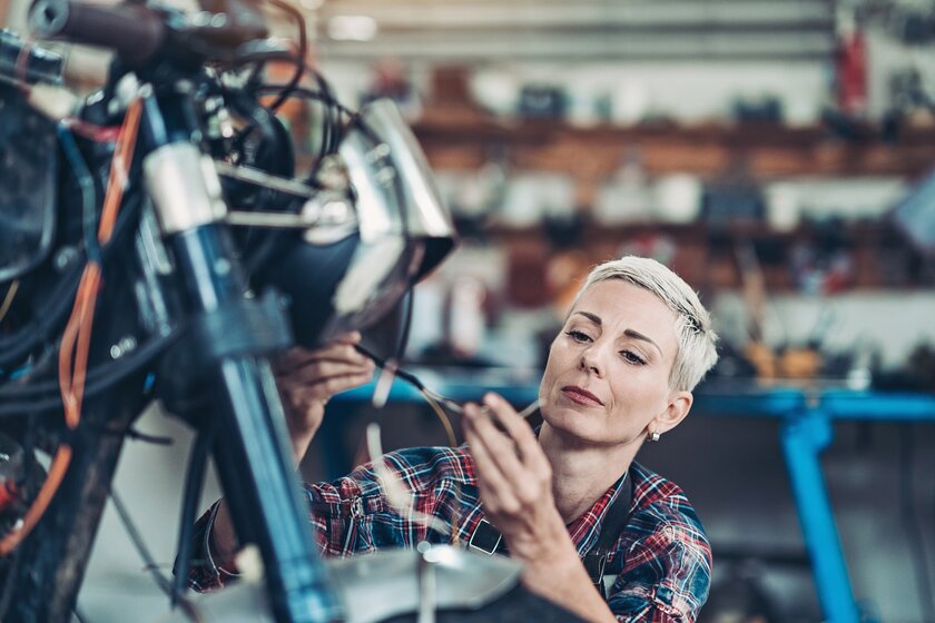Unternehmerin in ihrem Fahrradgeschäft prüft technische Details an einem Verkaufsobjekt. Unternehmerin in ihrem Fahrradgeschäft prüft technische Details an einem Verkaufsobjekt.