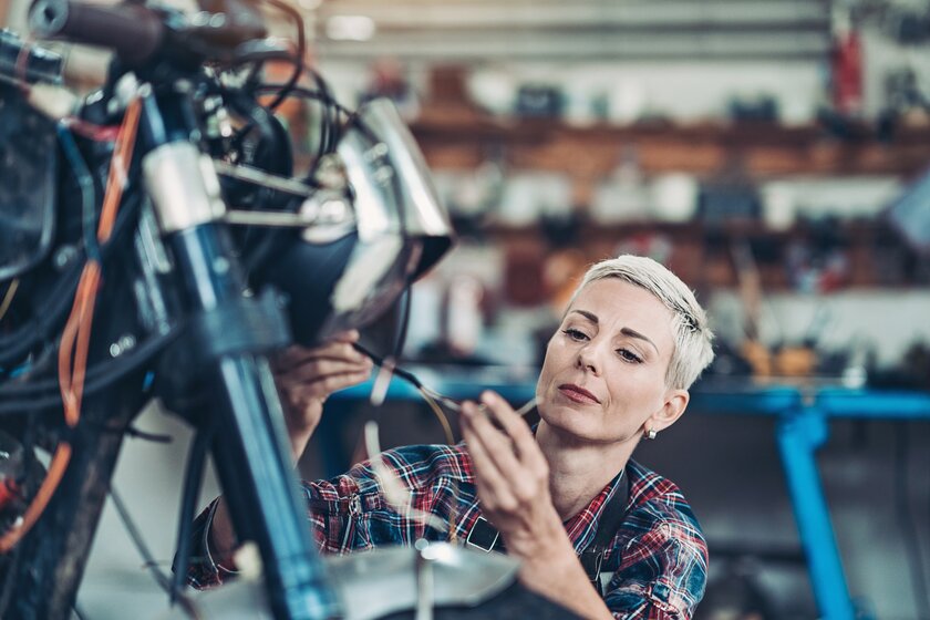 Unternehmerin in ihrem Fahrradgeschäft prüft technische Details an einem Verkaufsobjekt.