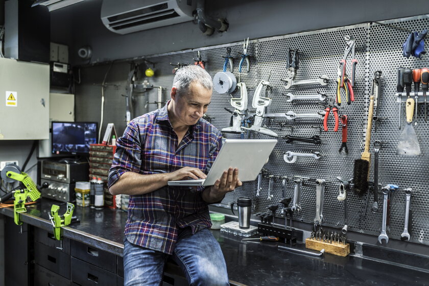 Ladenbesitzer Werkzeuge und Haushaltwaren erstellt am Laptop einen Businessplan Amazon Shop.