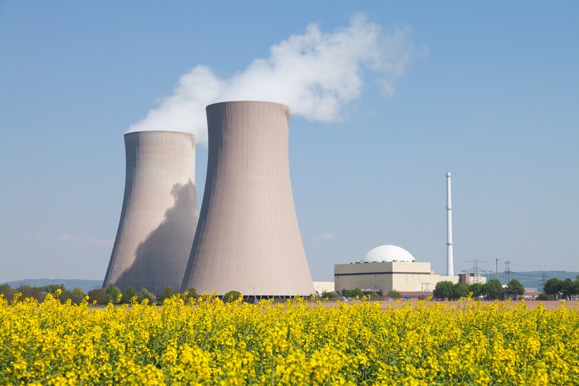 Atomkraftwerk mit dampfenden Kühltürmen, im Vordergrund ein Rapsfeld. Atomkraftwerk mit dampfenden Kühltürmen, im Vordergrund ein Rapsfeld.