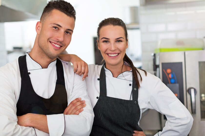 Weiblicher und männlicher Koch bilden ein funktionierendes Team, das sich gegenseitig stützt.
