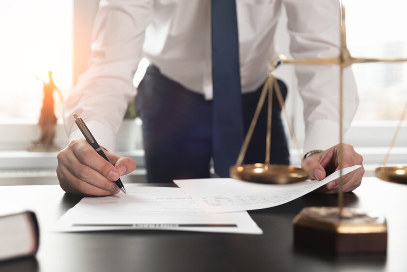 Unternehmer unterzeichnet Verträge zur Gründung einer Holding beim Notar. Unternehmer unterzeichnet Verträge zur Gründung einer Holding beim Notar.