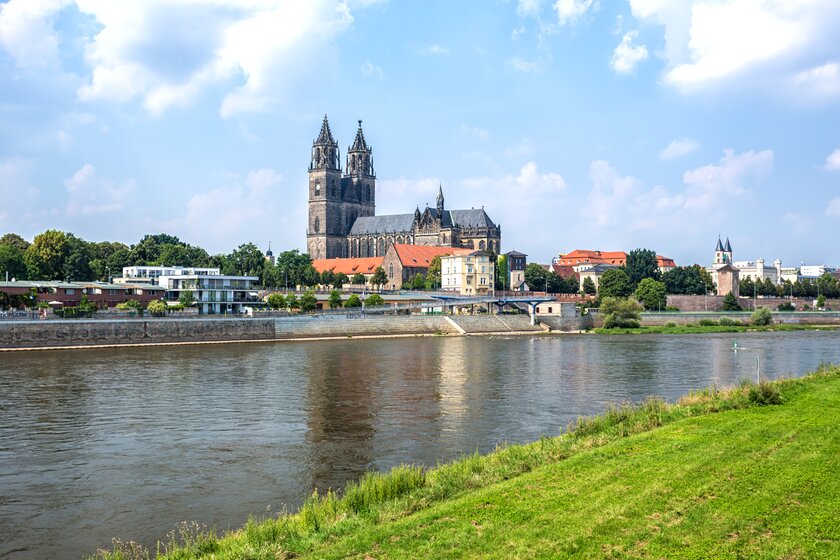 Blick auf die Elbe vor der Stadtkulisse Magdeburgs mit Fokus auf den Magdeburger Dom.