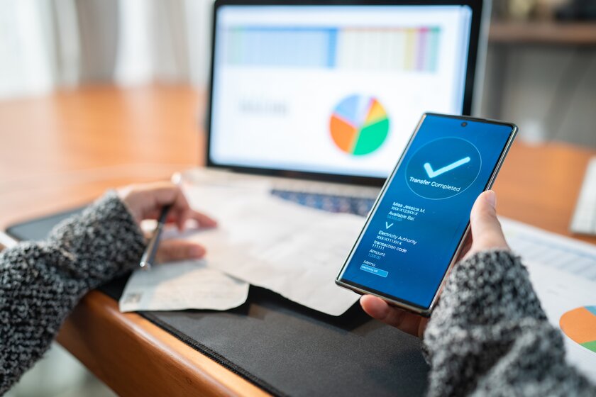 Heimischer Schreibtisch mit Computer und Banking App.