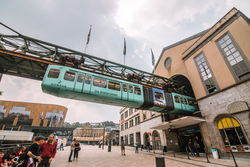 Blick auf die Wuppertaler Schwebebahn aus einem Haltepunkt herausfahrend.