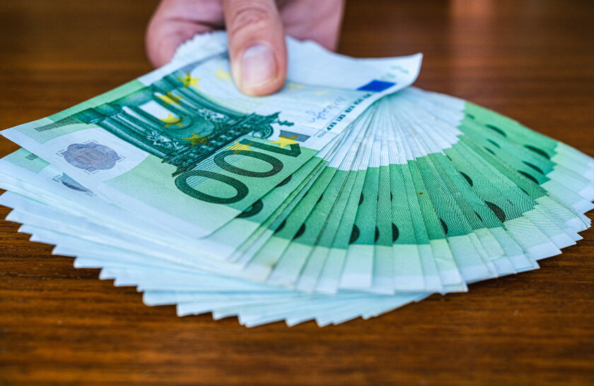 Hand zeigt sehr viele 100 Euro Banknoten.
