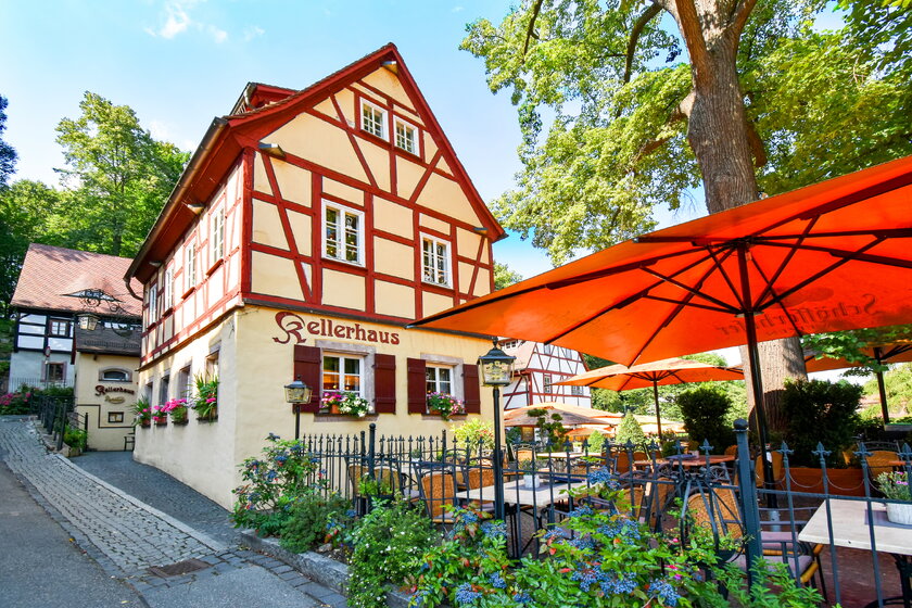 Blick auf ein Chemnitzer Fachwerkhaus mit sommerlichem Biergarten.