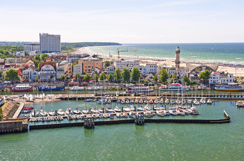 Seebad Warnemünde in der Hansestadt Rostock mit Blick auf Hafenpromenade, Leuchtturm und Strandhotel Neptun.