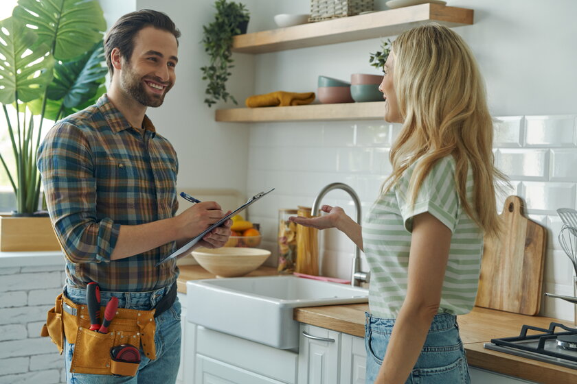 Installationsmeister bespricht Auftrag mit Kundin in Privatwohnung.