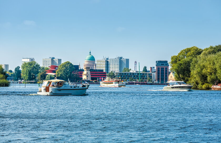 Blick auf Potsdamer Stadtkulisse vom Wasser aus mit Segelbooten.