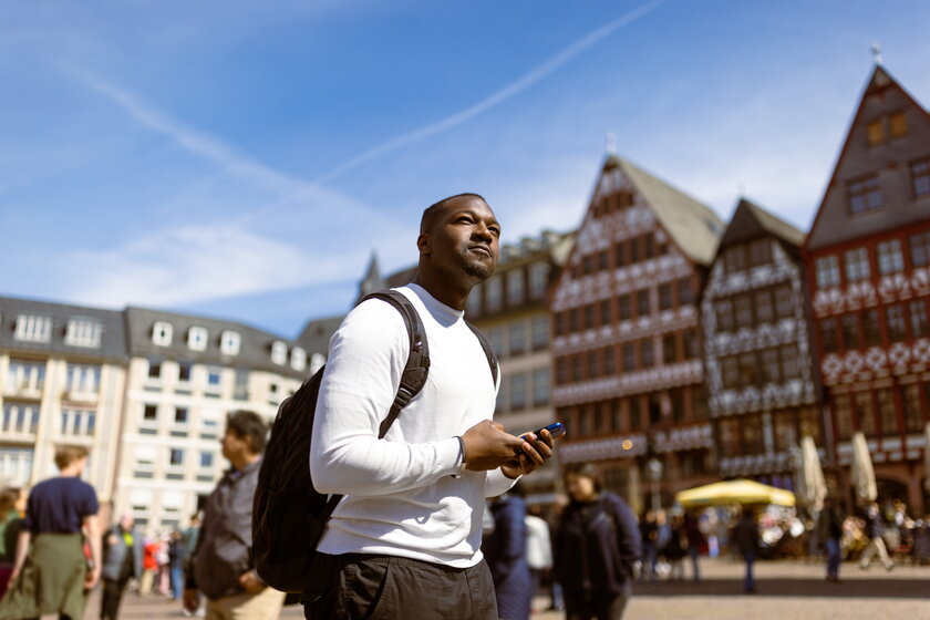 Lässiger schwarzer Mann erkundet Roemerplatz in Frankfurt
