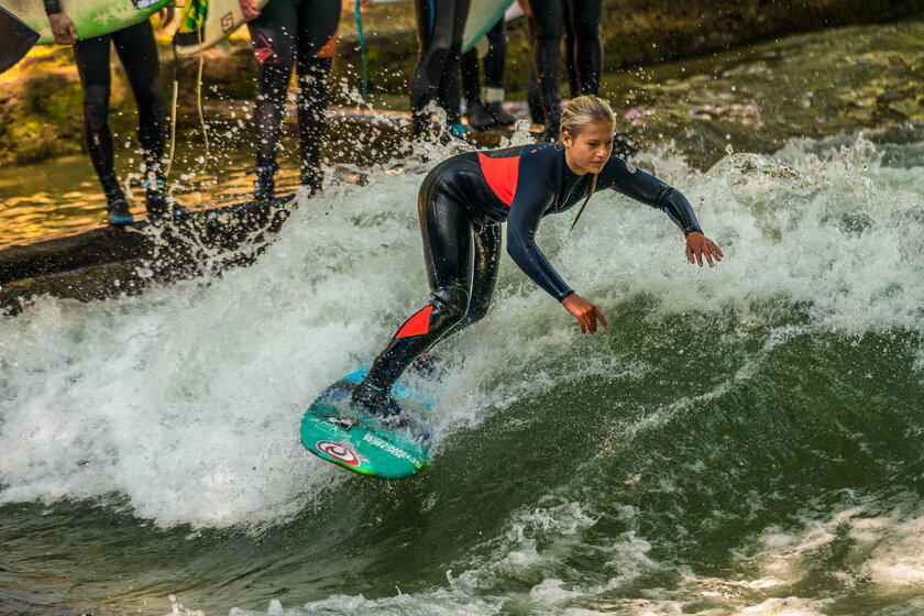 Junge Surferin auf dem Eisbach in Muenchen.