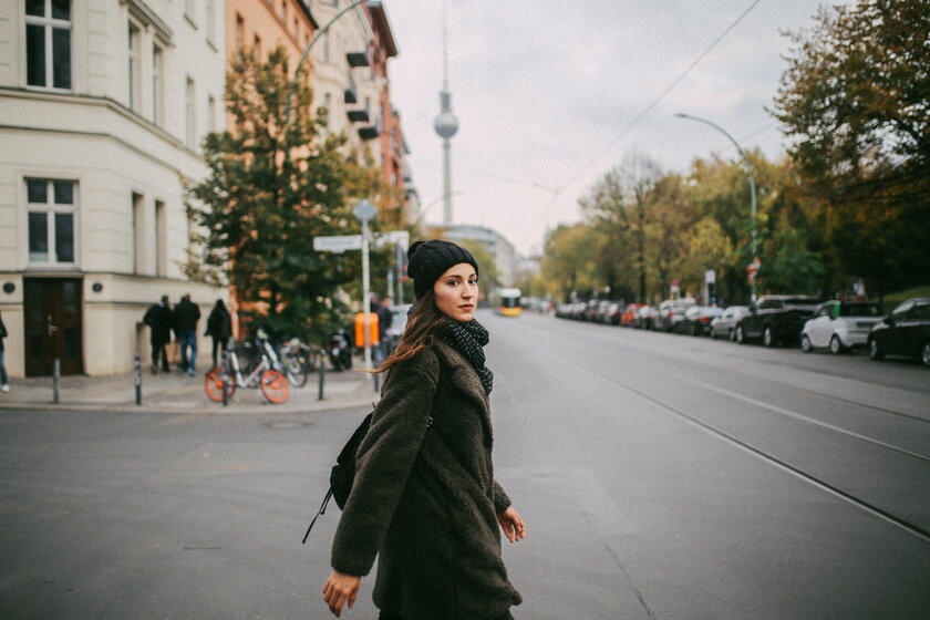 Bild Berliner Spaziergaengerin Junge Frau auf Strassenkreuzung, im Hintergrund Berliner Fernsehturm.