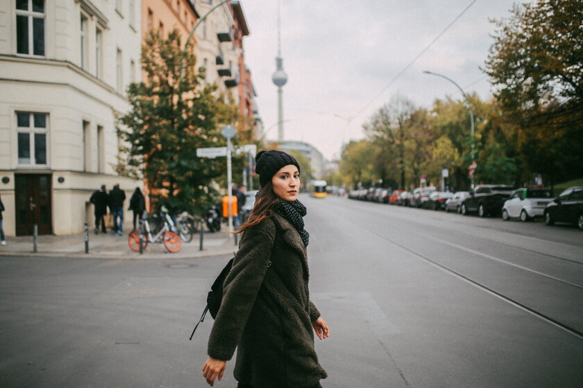 Junge Frau auf Strassenkreuzung, im Hintergrund Berliner Fernsehturm.