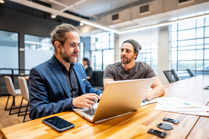Bild IHK Fachkundige Stelle IHK Mitarbeiter und Gruender besprechen gemeinsam Businessplan in modernem Buero.