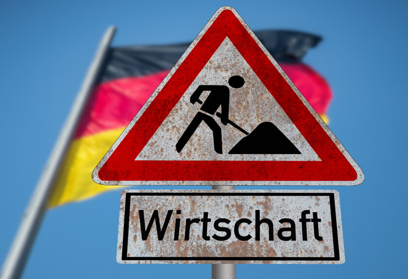 Bild Baustelle Wirtschaft Flagge von Deutschland weht hinter Verkehrsschild Baustelle Wirtschaft.