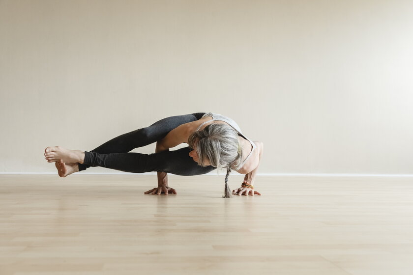 Bild Astavakrasana Fitte Yogi-Frau in Astavakrasana oder Acht-Winkel-Pose, eine Handausgleichs-Asana im modernen Yoga.