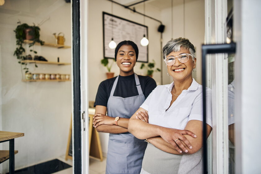 Senior Woman Manager Portrait mit junger Barista freuen sich über den Erfolg des Ladens.