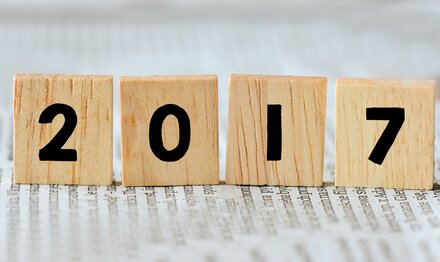 Businessnews für Unternehmer 2017 4 hölzerne Blöcke mit den Zahlen 2017 stehend auf einer Nachrichtenzeitung