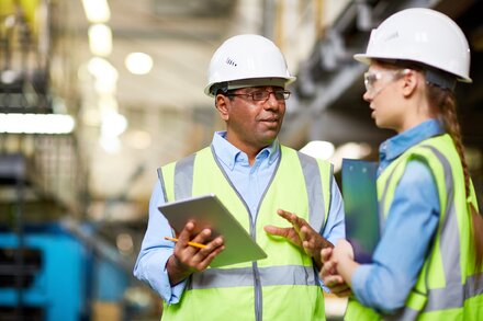 Mitarbeiter in Fabrik verwenden für Absprachen Tablet