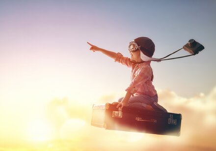 Kind als Entdecker fliegt auf Koffer der Sonne entgegen