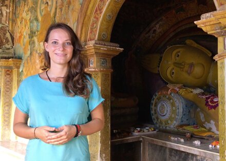 Onlinepsychologin Carolin Müller vor einem Buddhaschrein.